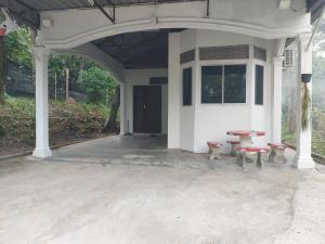 a porch of a house with a table and benches at SEROJA HOMESTAY in Baling