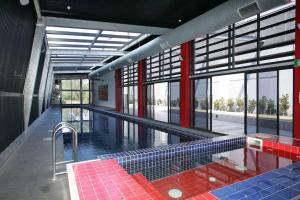 a large swimming pool with red and blue tiles in a building at Urban Uptown: Stylish Richmond in Melbourne