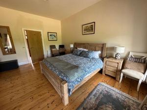 1 dormitorio con cama de madera y silla en Riverside converted Linen Mill, en Coleraine