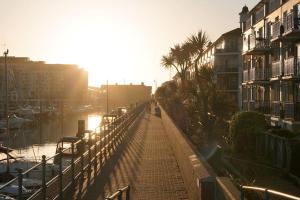 a bridge over a marina with palm trees and buildings at Stunning modern space with harbour views & free parking in Brighton & Hove
