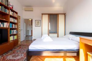 ミラノにあるGaribaldi Two Bedroomsのベッドルーム(ベッド1台、本棚付)