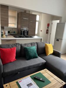 a living room with a gray couch with colorful pillows at Moorside House in Bolton