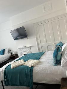 a bedroom with a bed with a tv on the wall at Moorside House in Bolton