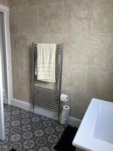 a bathroom with a towel hanging on a towel rack at Moorside House in Bolton