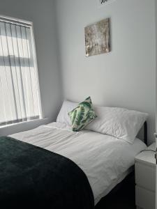 a bed in a bedroom with a picture on the wall at Moorside House in Bolton