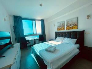 a bedroom with a bed and a desk and a television at Sea Breeze Studios in Netanya