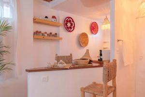 una cucina con bancone, sedie e piatti appesi al muro di Rooftop centre ville jacuzzi a Marrakech