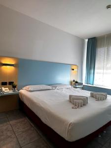 a bedroom with a large bed with two towels on it at Hotel Grecale - Venturina Terme in Venturina Terme