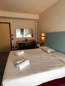 a bedroom with a large bed with towels on it at Hotel Grecale - Venturina Terme in Venturina Terme