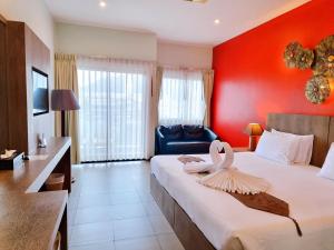 1 dormitorio con 1 cama grande y pared roja en Meir Jarr Hotel Patong, en Patong Beach