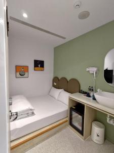 a small room with a bed and a sink at Planet 23 in Chiayi City