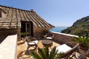 a patio with chairs and tables on top of a house at La Lanterna in Cetara