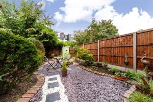 een tuin met een houten hek en een patio bij Charming Terraced 3BR House, 5 min Hither Green St in Londen