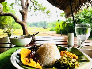 a plate of food with rice and vegetables on a table at Mahoora Wilpattu - by Eco Team in Wilpattu