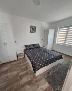 ein Schlafzimmer mit einem Bett in einem weißen Zimmer in der Unterkunft Apartmani KOKI Kladovo in Kladovo