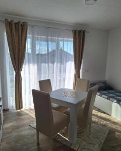 a dining room with a table and chairs and a bed at Apartmani KOKI Kladovo in Kladovo