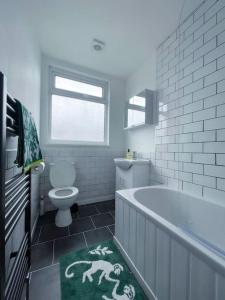 a bathroom with a bath tub and a toilet at Newly refurbished 3 bed house in Hull