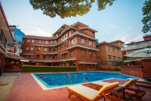 a large building with a swimming pool in front of it at Pashupati Boutique Hotel & Spa in Kathmandu