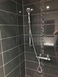 een douche met een douchekop in de badkamer bij La Casa Kemtio in Nollevaux