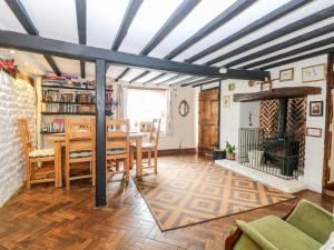 a dining room with a table and a fireplace at Garden House in Thetford