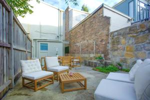 a patio with chairs and tables and a brick building at 3 Bedrooms - Darling Harbour - Glebe St 2 E-Bikes Included in Sydney