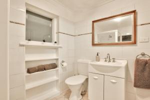 a white bathroom with a toilet and a sink at 3 Bedrooms - Darling Harbour - Glebe St 2 E-Bikes Included in Sydney