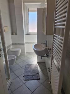 baño con 2 lavabos, aseo y ventana en Residenza Adriatica 4, en Roseto degli Abruzzi