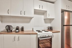 a kitchen with white cabinets and a stove at 3 Bedrooms - Darling Harbour - Glebe St 2 E-Bikes Included in Sydney