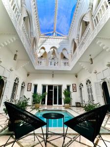 une piscine intérieure avec une table et des chaises dans un bâtiment dans l'établissement RIAD DREAMS, à Marrakech