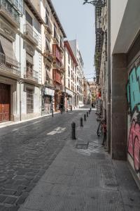 een lege straat in een stad met gebouwen bij tuGuest Postigo I Catedral Apartment in Granada