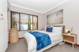 um quarto com uma cama grande e uma janela em The Atholls in Melrose em Joanesburgo