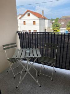 balcón con mesa de picnic y 2 sillas en Appartement cosy à 30 min Paris, Disney, CDG, en Chelles