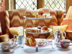 a table with three tiers of pastries and cups of coffee at Bespoke Log Cabin in Littlehampton