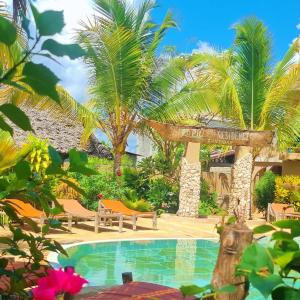 ein Resort mit einem Pool und Palmen in der Unterkunft Lapili Residence Apartments in Kiwengwa