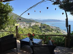a table and chairs with a view of the ocean at Il Melograno in Costa d'Amalfi - romantic experience in Vietri sul Mare