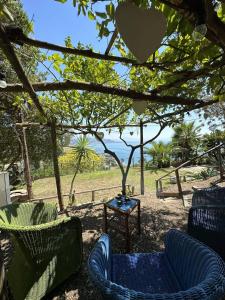patio z krzesłami i stołem z widokiem na ocean w obiekcie Il Melograno in Costa d'Amalfi - romantic experience w mieście Vietri sul Mare