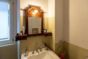 a bathroom with a sink and a mirror on the wall at Fiordaliso Apartment in Como