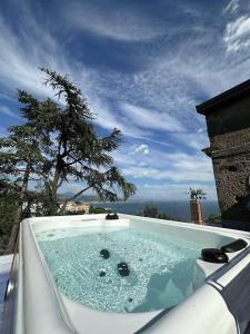 uma banheira de hidromassagem com uma árvore ao fundo em Il Melograno in Costa d'Amalfi - romantic experience em Vietri