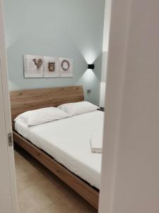 Schlafzimmer mit einem Bett mit weißer Bettwäsche in der Unterkunft Le Casuzze di Siculiana in Siculiana
