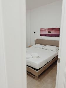 ein Schlafzimmer mit einem Bett und einem Wandgemälde in der Unterkunft Le Casuzze di Siculiana in Siculiana