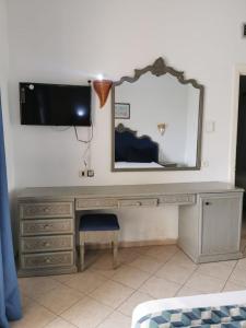 a desk with a mirror and a tv on a wall at Hotel Diar Yassine in Midoun