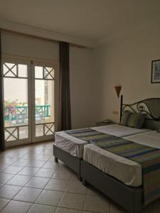a bedroom with a large bed and a balcony at Hotel Diar Yassine in Midoun