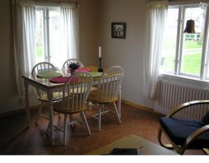 - une salle à manger avec une table, des chaises, une table et des fenêtres dans l'établissement Sydöstra Gotland, à Hemse