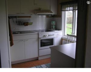 una cocina con electrodomésticos blancos y una ventana en Sydöstra Gotland, en Hemse