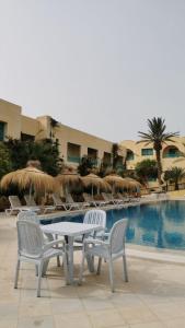 Hotel Diar Yassine في ميدون: طاولة وكراسي بجانب مسبح