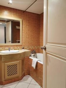 a bathroom with a sink and a tub and a mirror at Hotel Diar Yassine in Midoun