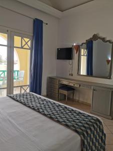 1 dormitorio con cama, escritorio y espejo en Hotel Diar Yassine en Midoun