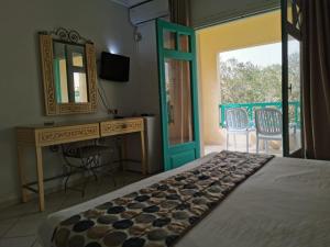 a bedroom with a bed and a desk and a mirror at Hotel Diar Yassine in Midoun +62 photos