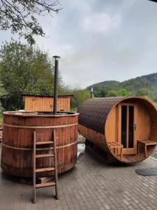two large wooden barrels sitting next to a house at Casa PICY Vendégház in Sovata