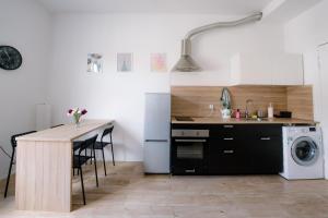 een keuken met een tafel en een wasmachine bij Restful Stay Apartment in Grudziądz